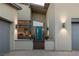 A contemporary home entrance featuring a striking turquoise door, stylish lighting fixtures, and a well-manicured walkway at 10271 Meridian Hill Ave, Las Vegas, NV 89135