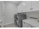 Clean laundry room with modern washer and dryer, white cabinets, and stylish countertops at 10271 Meridian Hill Ave, Las Vegas, NV 89135