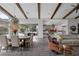Open concept living and dining space with vaulted ceilings, wood beams, and views of the backyard at 10271 Meridian Hill Ave, Las Vegas, NV 89135