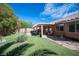 Spacious backyard featuring a covered patio perfect for entertaining and a well-maintained artificial grass area at 1072 Pennyfeather Rd, Henderson, NV 89015