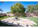 Backyard featuring a custom stone fire pit, artificial grass, and desert landscaping at 1072 Pennyfeather Rd, Henderson, NV 89015