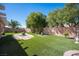 Large backyard with artificial grass and a custom stone fire pit at 1072 Pennyfeather Rd, Henderson, NV 89015