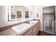 Bathroom featuring double sinks, modern vanity and lighted mirror at 1072 Pennyfeather Rd, Henderson, NV 89015