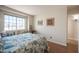 Bedroom showcasing a decorative bedspread, a large window, and artistic wall decor for a cozy ambiance at 1072 Pennyfeather Rd, Henderson, NV 89015