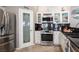 Bright kitchen featuring white cabinets, stainless steel appliances, and a decorative pantry door at 1072 Pennyfeather Rd, Henderson, NV 89015
