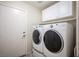 Laundry room with washer and dryer, storage cabinets, and exterior door at 1072 Pennyfeather Rd, Henderson, NV 89015