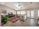 Bright living room featuring tile floors, vaulted ceilings, a ceiling fan, and a cozy seating arrangement at 1072 Pennyfeather Rd, Henderson, NV 89015