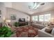 Bright living room featuring tile floors, vaulted ceilings, a ceiling fan, and a cozy seating arrangement at 1072 Pennyfeather Rd, Henderson, NV 89015