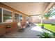 Covered patio with rocking chairs, offering a peaceful outdoor space with desert landscaping at 1072 Pennyfeather Rd, Henderson, NV 89015