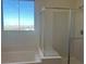 Bathroom featuring a soaking tub with a glass-enclosed shower and a large window at 12434 Parkscene Pl, Las Vegas, NV 89138