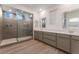 Bright bathroom features a double vanity, wood flooring, and large glass shower with upgraded tile at 12457 Sunset Sage Ave, Las Vegas, NV 89138
