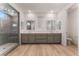 Bright bathroom features a double vanity, wood flooring, and large glass shower with upgraded tile at 12457 Sunset Sage Ave, Las Vegas, NV 89138