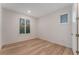 Inviting bedroom with wood floors, natural light from shuttered windows, and a white door at 12457 Sunset Sage Ave, Las Vegas, NV 89138