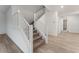 Bright hallway and staircase with light wood floors, and a white railing at 12457 Sunset Sage Ave, Las Vegas, NV 89138