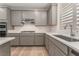 A spacious kitchen with wood flooring, stainless steel appliances, an island with seating, and white countertops at 12457 Sunset Sage Ave, Las Vegas, NV 89138