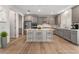 A spacious kitchen with wood flooring, stainless steel appliances, an island with seating, and white countertops at 12457 Sunset Sage Ave, Las Vegas, NV 89138