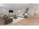 Spacious, virtually staged living room with wood flooring, stairs, and nice furniture at 12457 Sunset Sage Ave, Las Vegas, NV 89138