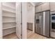 View of walk-in pantry with shelving adjacent to stainless steel refrigerator at 12457 Sunset Sage Ave, Las Vegas, NV 89138