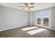 Sunlit bedroom features wood-look floors, neutral walls, ceiling fan, and a glass door to the balcony at 1967 N Moapa Valley Blvd, Logandale, NV 89021