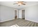 Bright bedroom with wood-look floors, ceiling fan, and adjacent bathroom and closet at 1967 N Moapa Valley Blvd, Logandale, NV 89021