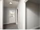 Bright hallway with gray wood floors leading to a white door with a window for natural light at 1967 N Moapa Valley Blvd, Logandale, NV 89021