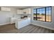 Bright kitchen features white cabinetry, marble countertops, an island, and a window overlooking the front yard at 1967 N Moapa Valley Blvd, Logandale, NV 89021