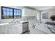 Well-lit kitchen featuring white cabinets, marble countertops, stainless steel appliances, and modern fixtures for a clean design at 1967 N Moapa Valley Blvd, Logandale, NV 89021