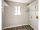 Bright laundry room with gray wood floor, window, and convenient built-in shelving for easy organization at 1967 N Moapa Valley Blvd, Logandale, NV 89021