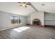 Well-lit living room featuring a brick fireplace, large windows, ceiling fan, and wood-look floors at 1967 N Moapa Valley Blvd, Logandale, NV 89021