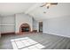 Bright living room featuring a brick fireplace, ceiling fan, and grey wood-look floors at 1967 N Moapa Valley Blvd, Logandale, NV 89021