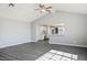 Open-concept living room featuring vaulted ceiling, ceiling fan, and grey wood-look floors at 1967 N Moapa Valley Blvd, Logandale, NV 89021