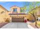 Two-story home featuring a covered entryway, two-car garage and desert landscaping at 1988 Villa De Sol St, Las Vegas, NV 89156