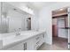 Bright bathroom with dual sinks, white cabinets, and a large mirror at 2211 Arborwood Way, Las Vegas, NV 89142