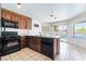 Well-lit kitchen features wood cabinets, granite countertops, and direct access to backyard pool at 2211 Arborwood Way, Las Vegas, NV 89142