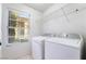 A practical laundry room with a side by side washer and dryer setup and shelving at 2211 Arborwood Way, Las Vegas, NV 89142