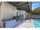Outdoor kitchen with stainless steel grill and sink, perfect for entertaining by the pool at 2211 Arborwood Way, Las Vegas, NV 89142