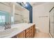 Bright bathroom featuring double sinks, wood cabinets and a separate shower at 2324 Willow Wren Dr, North Las Vegas, NV 89084