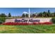 Sun City Aliante community entrance sign surrounded by meticulously landscaped grounds and vibrant red flowers at 2324 Willow Wren Dr, North Las Vegas, NV 89084
