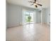 Open living space with neutral paint, tile flooring, and large glass doors to the backyard at 2324 Willow Wren Dr, North Las Vegas, NV 89084