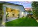 Lush backyard with green grass, covered patio, and well-maintained landscaping at 2386 Millergrove Ave, North Las Vegas, NV 89086