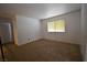 A sunlit bedroom features neutral carpeting and a window for natural light at 2431 Old Forge Ln # 101, Las Vegas, NV 89121