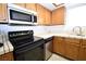 Cozy kitchen featuring oak cabinets, stainless steel appliances, and tile countertops at 2431 Old Forge Ln # 101, Las Vegas, NV 89121