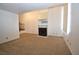 Open-concept living room featuring carpet, a fireplace, and staircase to second level at 2431 Old Forge Ln # 101, Las Vegas, NV 89121
