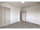 A carpeted bedroom features a closet with double doors and a view to another room at 2621 Bello Dr, North Las Vegas, NV 89030