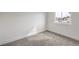 A bright bedroom with carpet, white walls, baseboards and a view from the window at 2621 Bello Dr, North Las Vegas, NV 89030