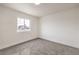 A bright bedroom with carpet, white walls, baseboards and a view from the window at 2621 Bello Dr, North Las Vegas, NV 89030