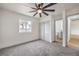 Bright bedroom features plush carpeting, a modern ceiling fan, and a window with tree view at 2621 Bello Dr, North Las Vegas, NV 89030