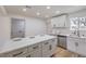Bright kitchen features a center island with seating, quartz countertops, and stainless steel appliances at 2621 Bello Dr, North Las Vegas, NV 89030