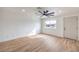 Open living room features wood-look floors, a modern ceiling fan, window to the front yard, and white trim at 2621 Bello Dr, North Las Vegas, NV 89030