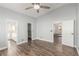 Large bedroom featuring neutral walls, a ceiling fan, and three doors leading to closet, bathroom and hallway at 2842 Mahogany Grove Ave, Henderson, NV 89074